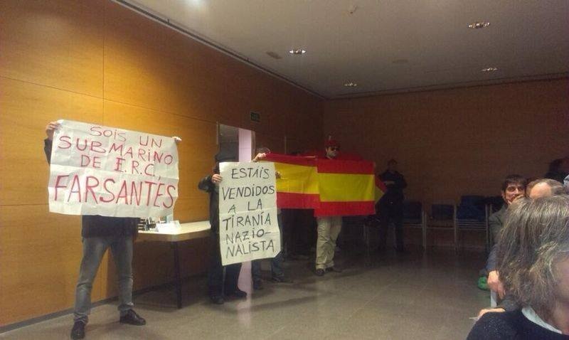 Los asaltantes despliegan banderas de España en la tarima de la sala.