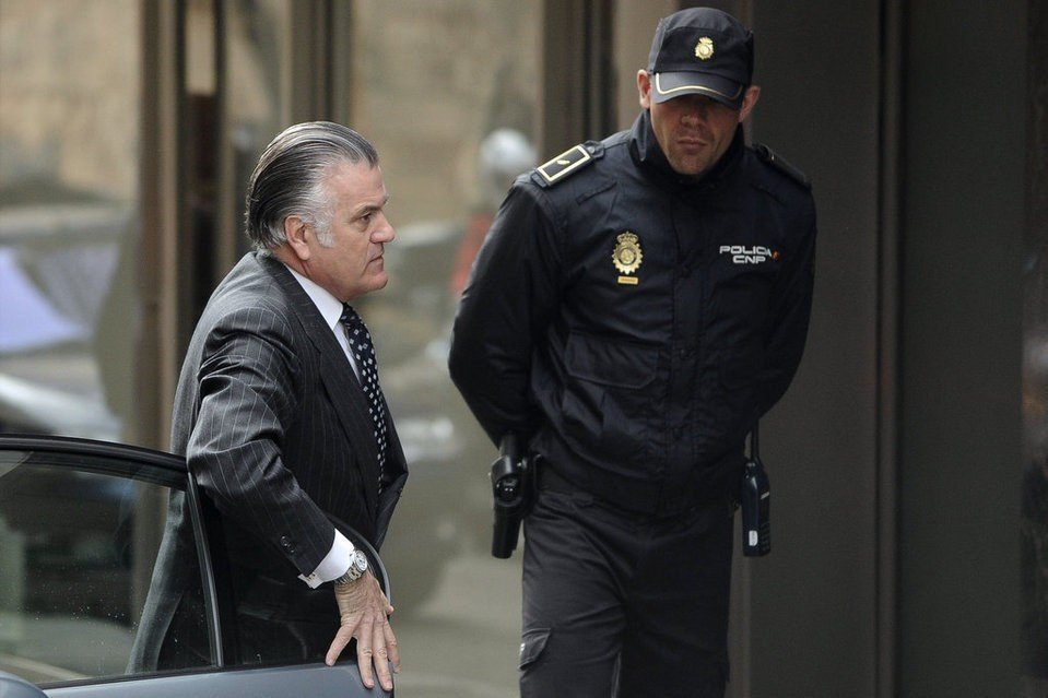 Luis Bárcenas custodiado por un policía.
