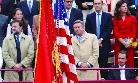 Zapatero sentado al paso de la bandera de USA.