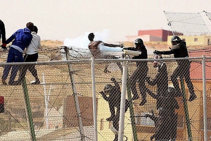 Guardias Civiles interceptan a inmigrantes en la valla de Melilla.