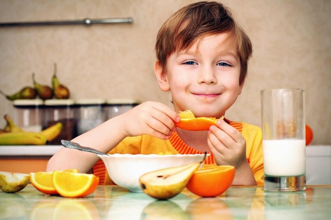 Un niño comiendo fruta. 