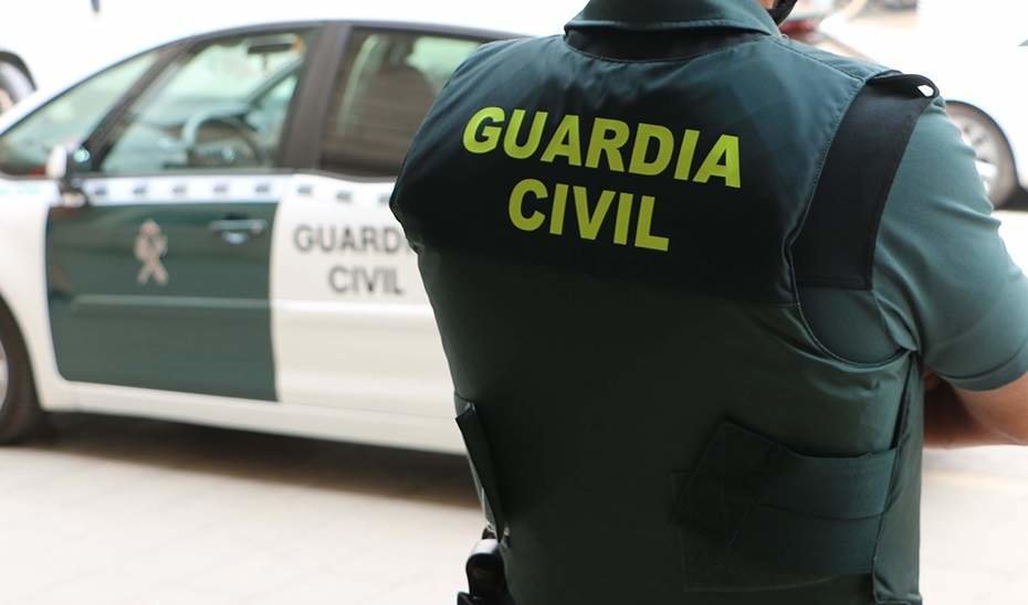 Un agente de la Guardia Civil, de espaldas, junto a un vehículo oficial.
GUARDIA CIVIL