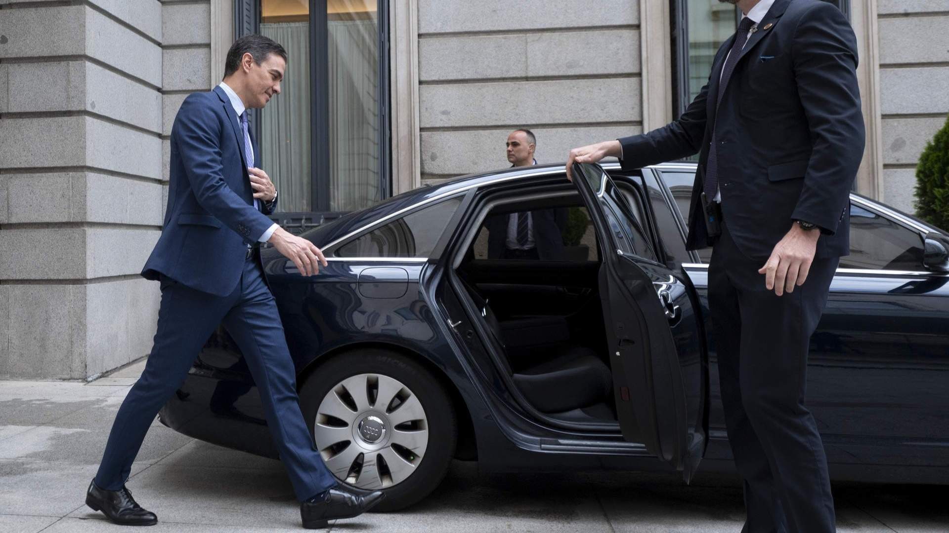 Un escolta le abre la puerta del coche a Pedro Sánchez.