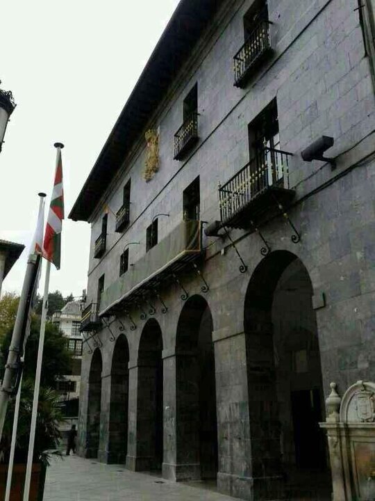 Las banderas del Pa&iacute;s Vasco y de Guip&uacute;zcoa en sus m&aacute;stiles, y la peque&ntilde;a ense&ntilde;a espa&ntilde;ola en un balc&oacute;n.