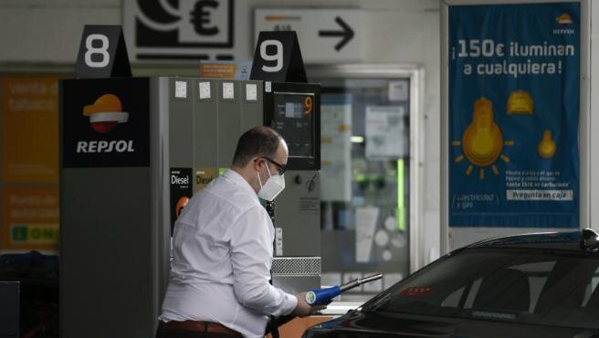 Un hombre echa gasolina a su coche en una gasolinera.