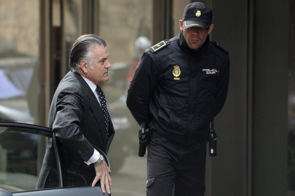 Luis Bárcenas custodiado por un policía.
