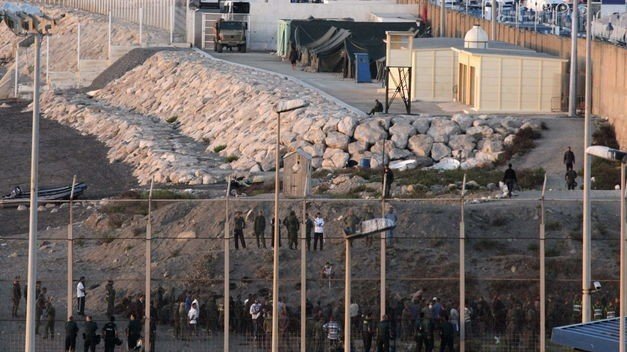 Inmigrantes subsaharianos tratan de saltar la valla de Ceuta.