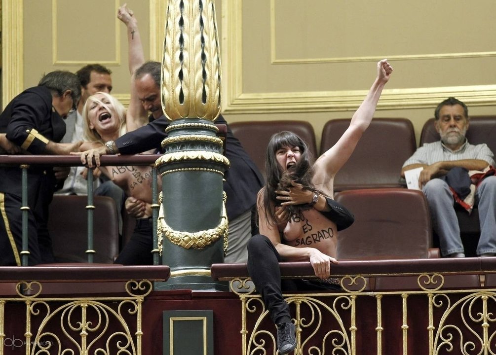 Los ujieres del Congreso tratan de llevarse a las activistas de Femen de la tribuna de invitados.