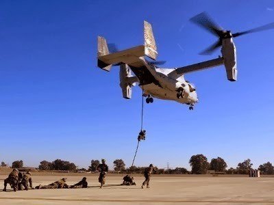 Marines descendiendo de un avión vertical MV-22 Osprey.