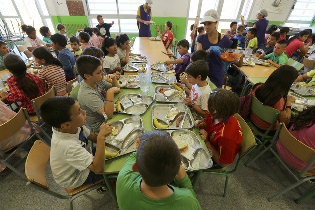 Niños comiendo en el comedor de un colegio.
