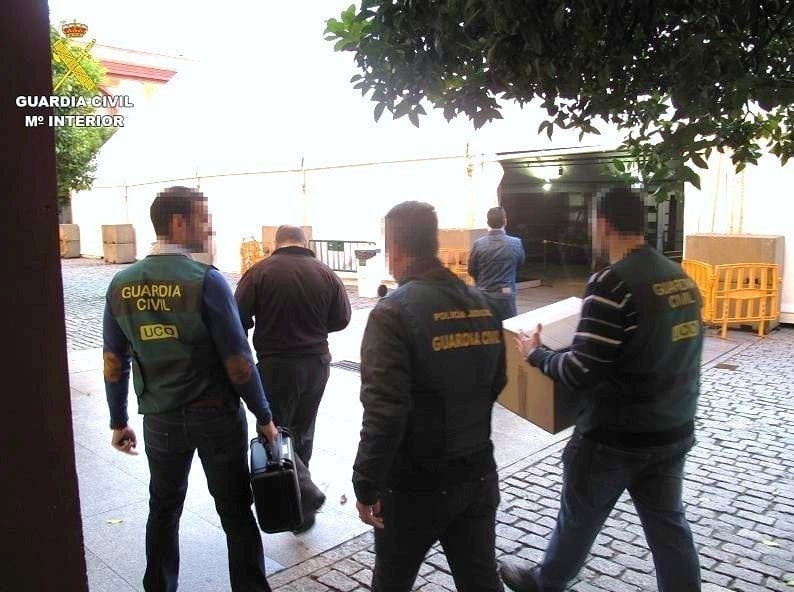 Agentes de la UCO de la Guardia Civil se llevan material intervenido en la Operación Enredadera.