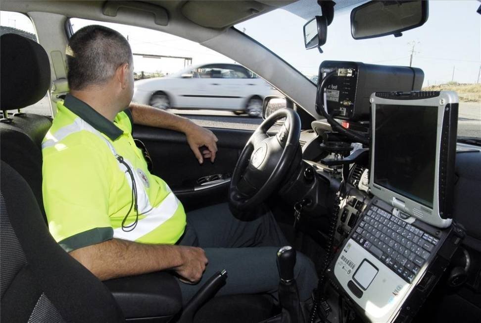 Un agente de la Guardia Civil controlando la velocidad de los vehículos