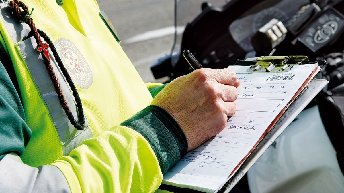 Un agente de la Guardia Civil pone una multa a un conductor por exceso de velocidad al volante. 