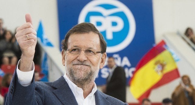Mariano Rajoy en un acto del Partido Popular, con el logo detrás.