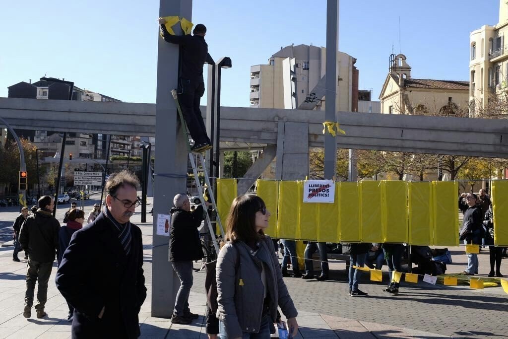 Independentistas colocando pancartas y lazos amarillos en Barcelona.