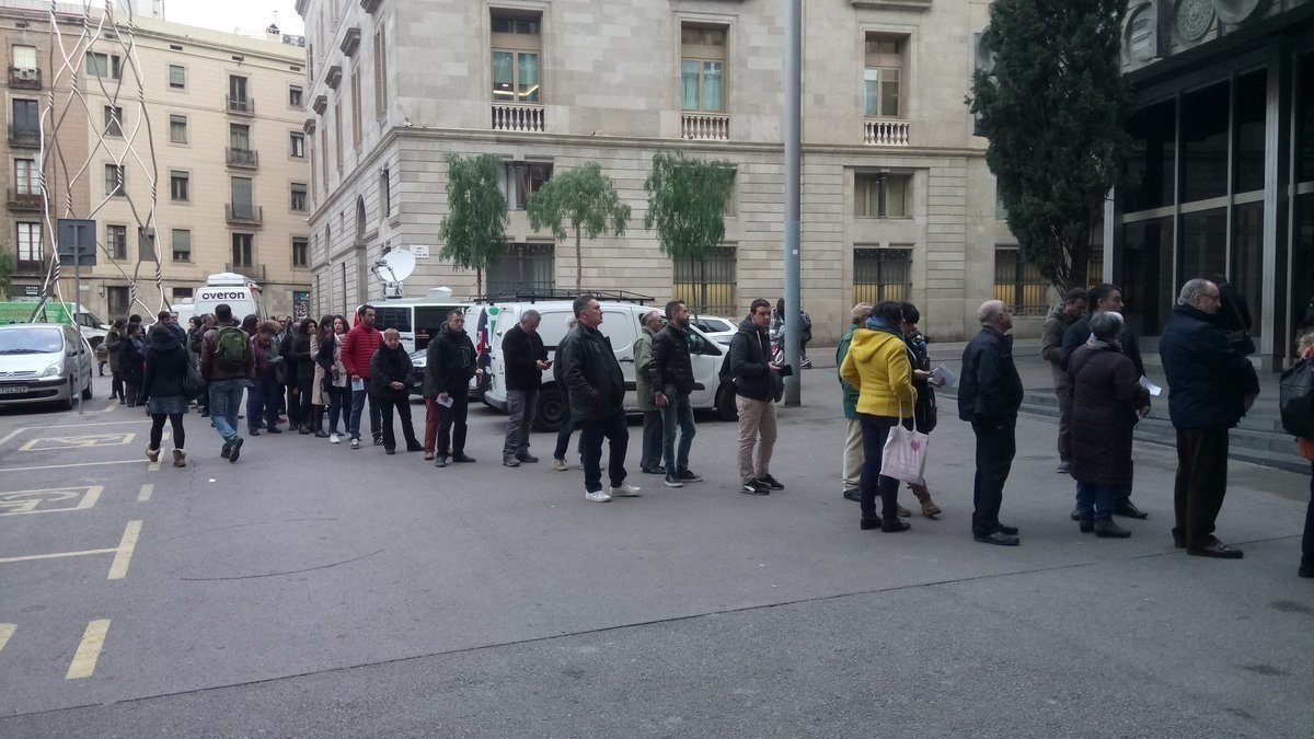 Largas hileras de votantes ante un colegio electoral de Cataluña.