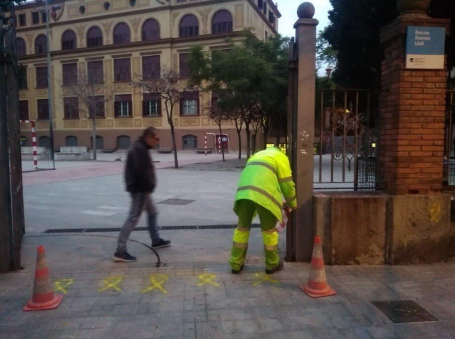 Operarios de limpieza borran lazos amarillos en un colegio electoral de Barcelona (Foto: @bcadilla).