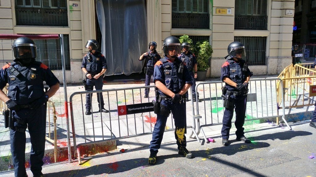 Mossos manchados de pintura ante la Jefatura Superior de Policía, en Barcelona.