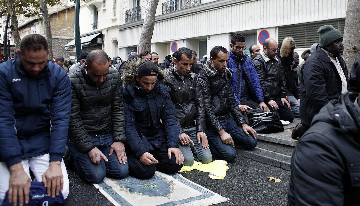 Musulmanes protestan rezando en una calle en París.