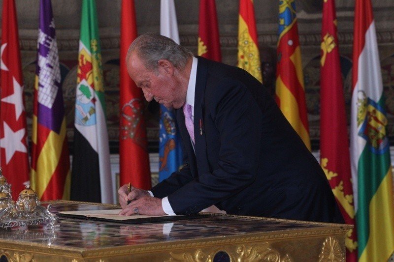 Juan Carlos I firma la ley orgánica por la que abdicó en Felipe VI, el 18 de junio de 2014.