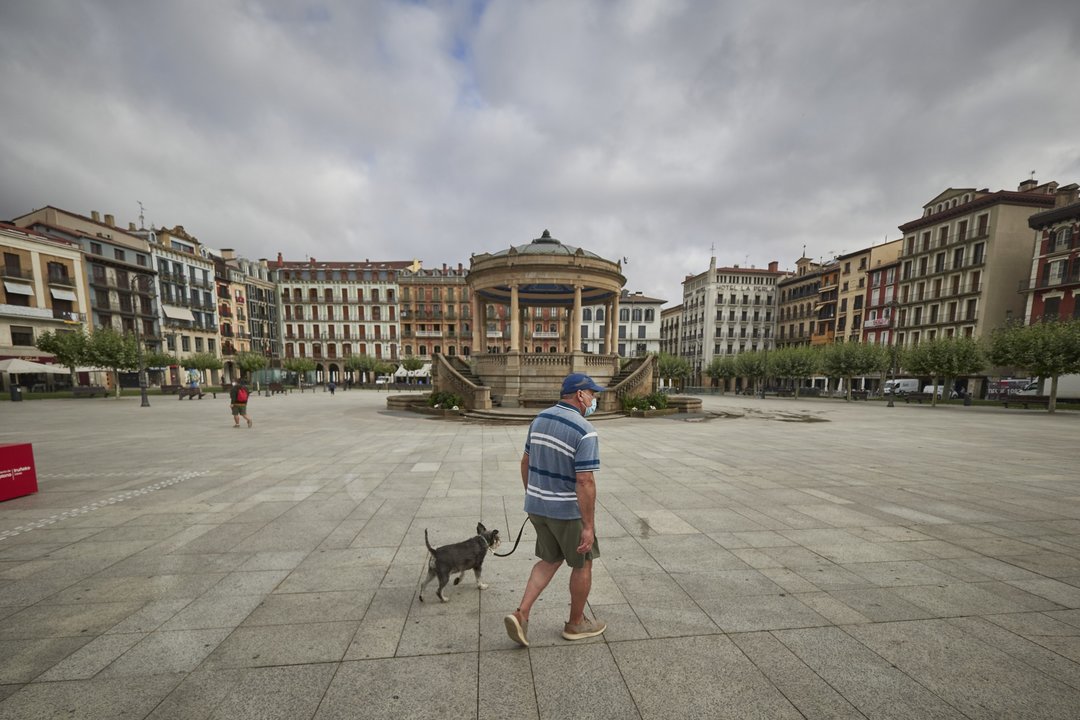 un señor pasea al perro por la plaza del castillo de Pamplona, durante el Primer dia de obligatoriedad de mascarillas en la comunidad Foral de Navarrea . 17 de julio 2020.