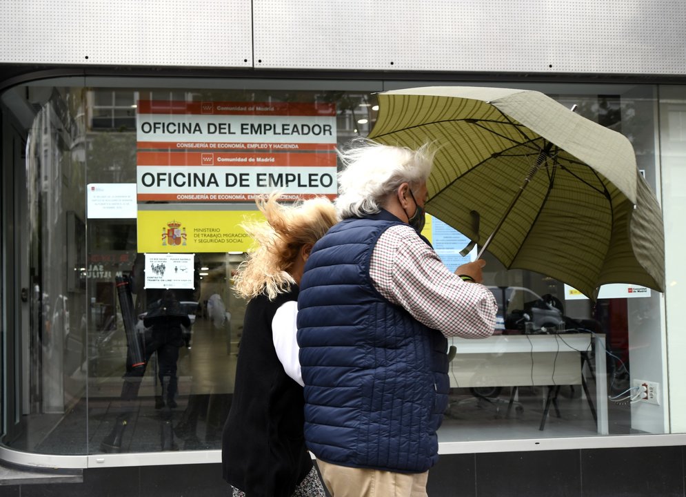 Una pareja pasa al lado de una Oficina de Empleo en Madrid 