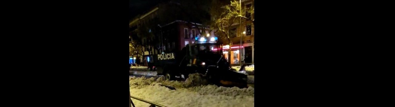 Camión de la Policía Nacional retira nieve en una calle de Madrid.