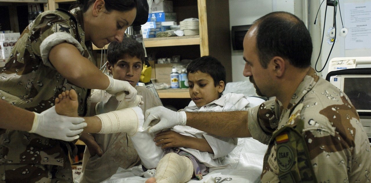 Los tenientes enfermeros Arévalo y Hossein realizan una cura de las quemaduras que padece el niño afgano Rached, en el destacamento español del PRT de Qala i Naw.