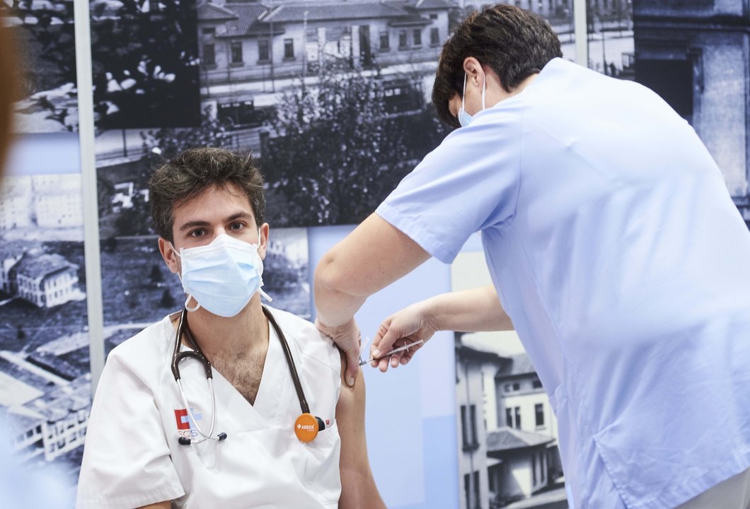 Una trabajadora sanitaria inyecta la segunda dosis de la vacuna de Pfizer-BioNTech contra la Covid-19 a un sanitario del Hospital Universitario Marqués de Valdecilla, en Santander, Cantabria