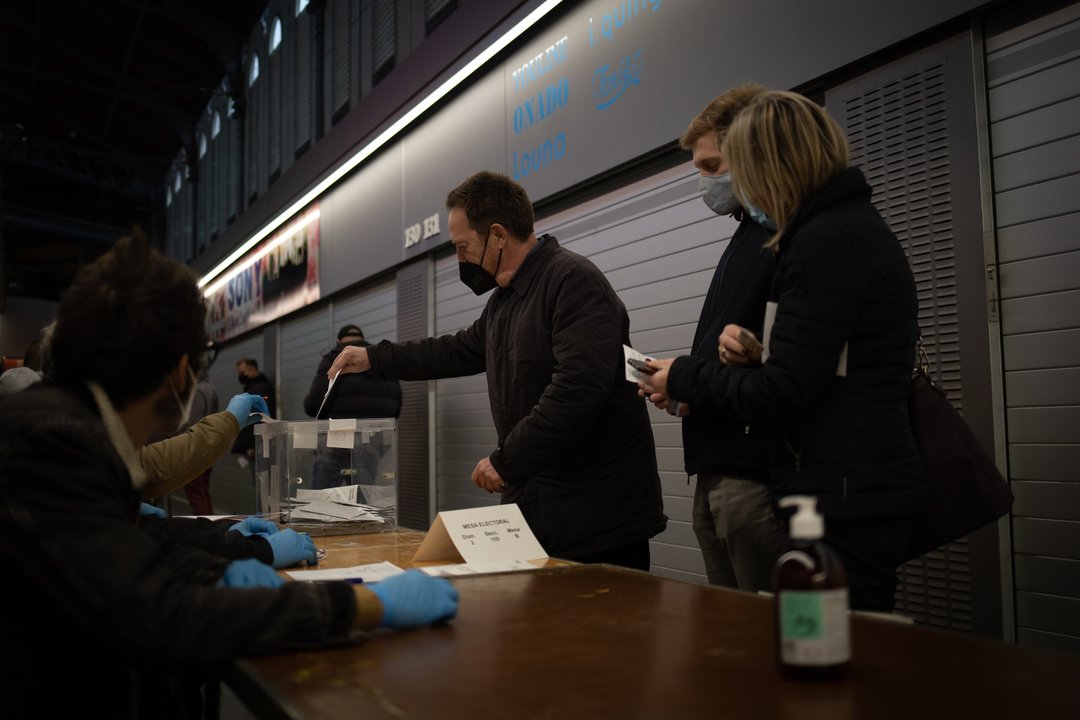 Un hombre vota en una mesa electoral del Mercado St. Antoni en Barcelona, Cataluña