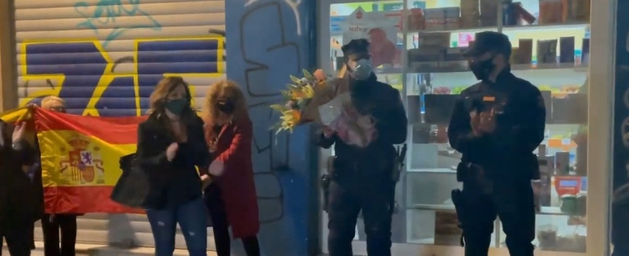 Policías antidisturbios reciben un ramo de flores en Valencia.