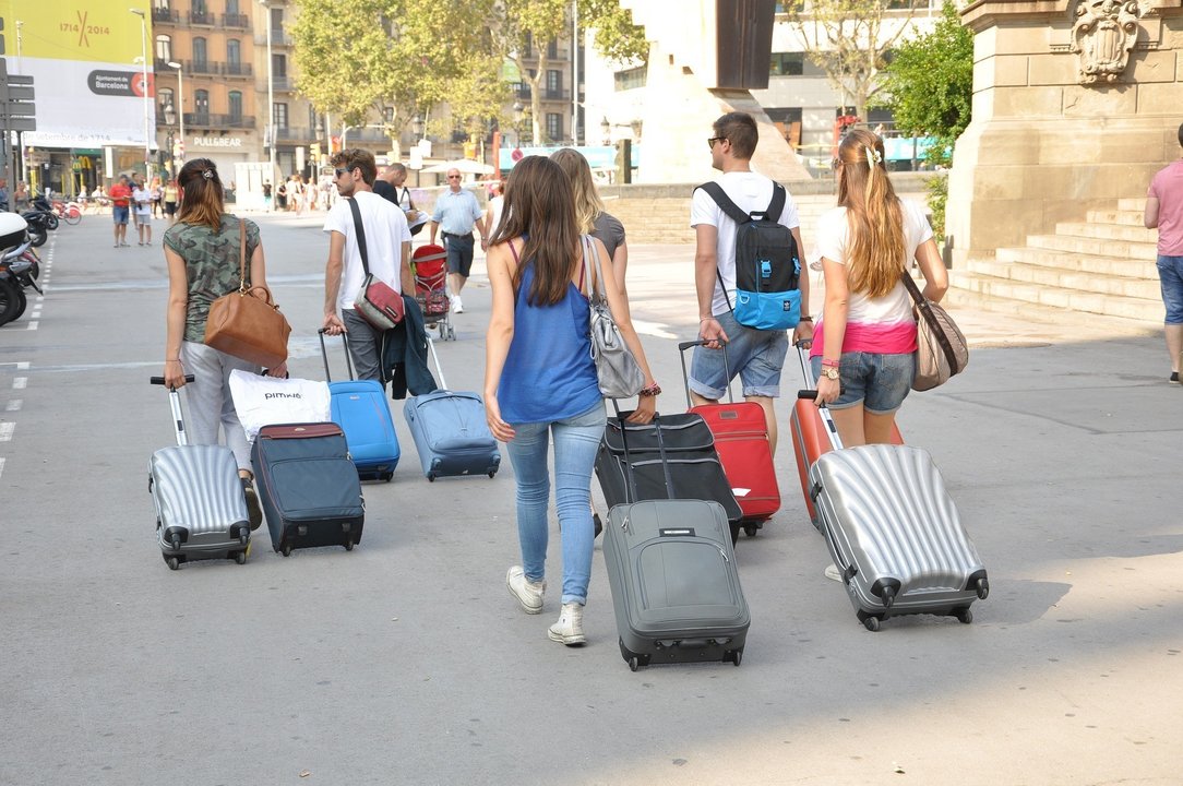 Varias personas con sus maletas.