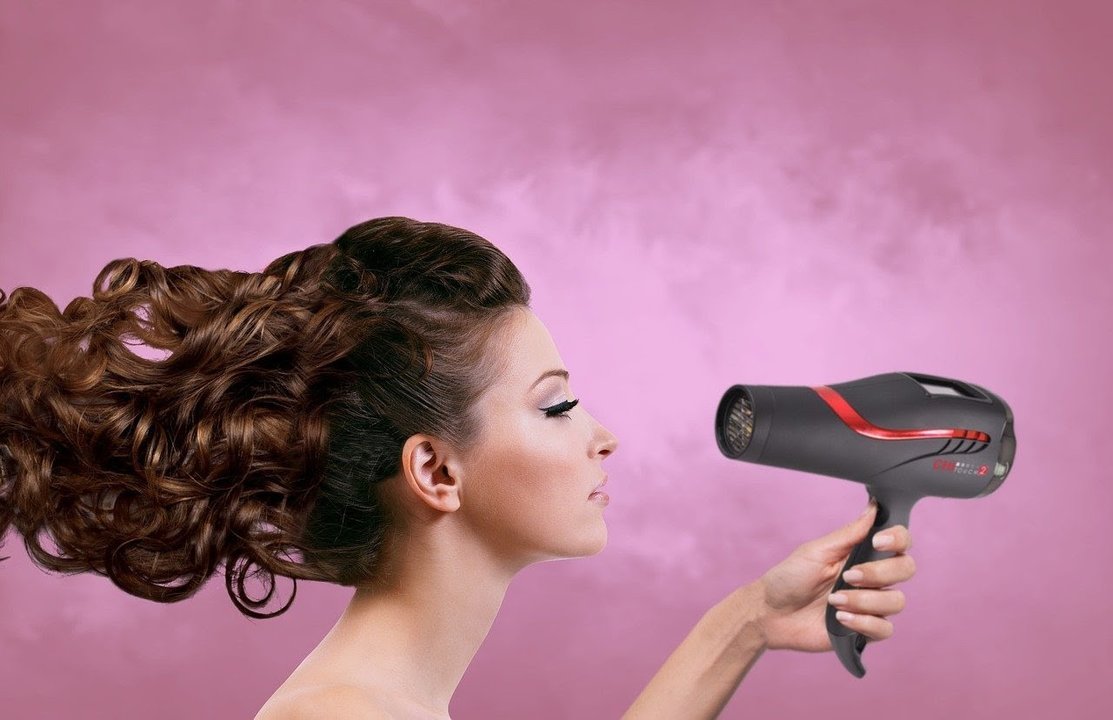 Una mujer con un secador de pelo.