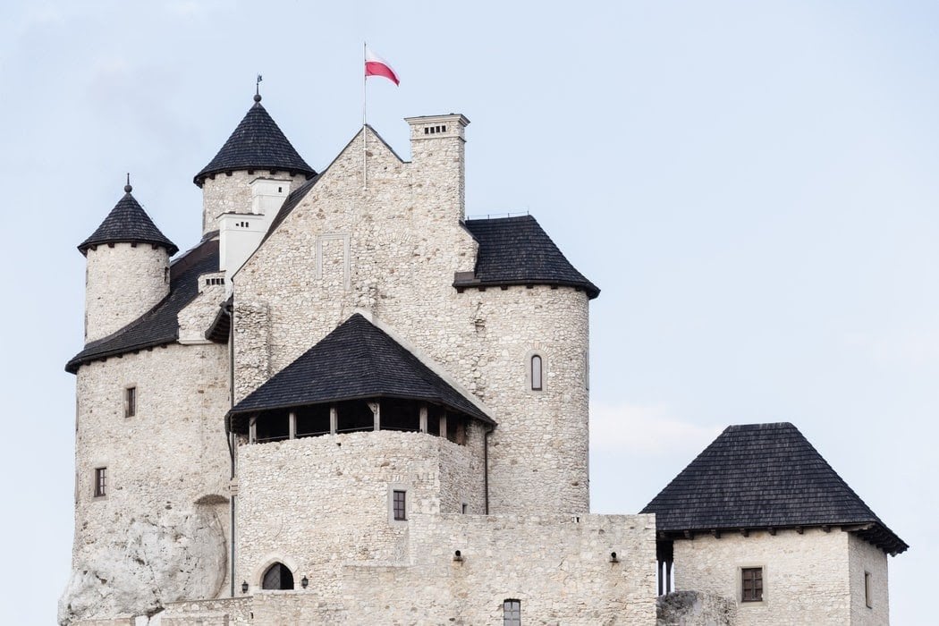 Un castillo sobre el que ondea la bandera polaca.