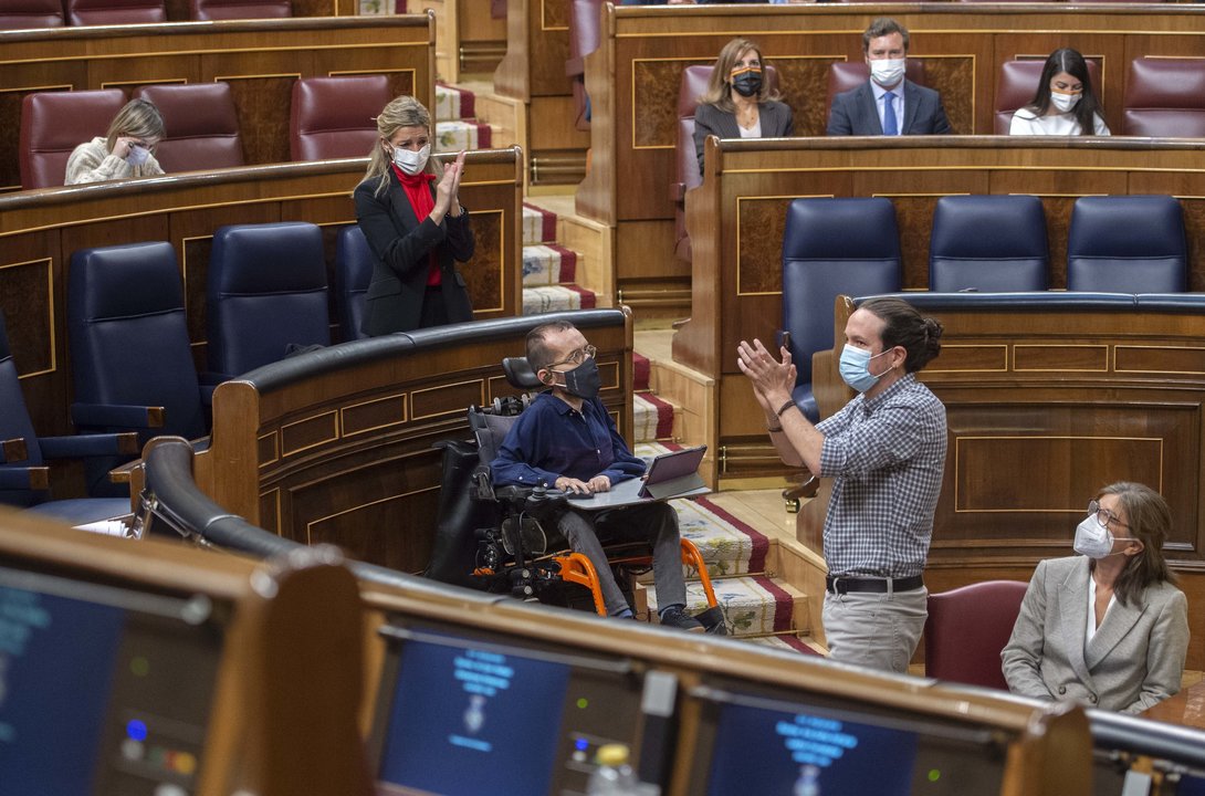 La ministra de Trabajo, Yolanda Díaz, aplaude al vicepresidente segundo del Gobierno, Pablo Iglesias (d), durante una sesión plenaria en el Congreso de los Diputados, Madrid, (España), a 24 de marzo de 2021. (Foto: A.Ortega.POOL / Europa Press)