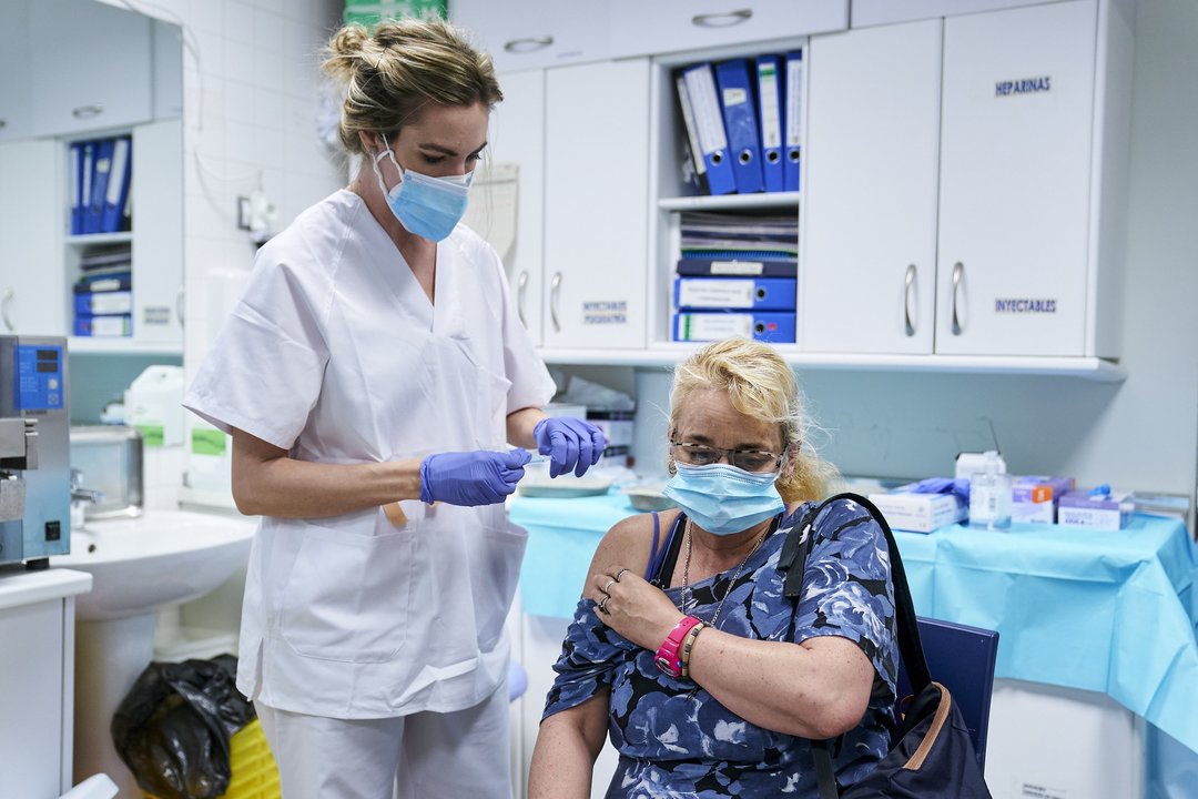 Una sanitaria vacuna a una mujer sin hogar en el Centro de Acogida Municipal Para Personas Sin Hogar San Isidro, a 20 de mayo de 2021, en Madrid (España). L