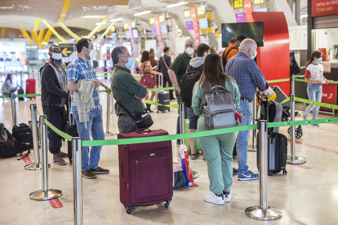 Varias personas hacen fila con maletas en la terminal T4 del Aeropuerto Adolfo Suárez Madrid-Barajas.