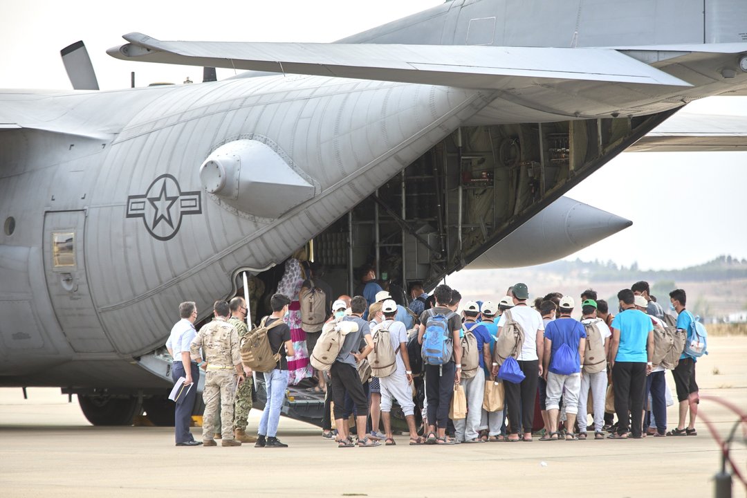 Un grupo de jóvenes y familias afganas, se dirigen a subir a un avión estadounidense para ser trasladados a Alemania, en la base aérea de Torrejón de Ardoz, a 24 de agosto de 2021, en Madrid (España).