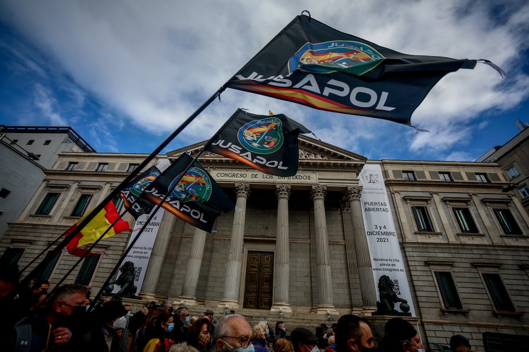 Varias personas sostienen banderas del sindicato policial Jusapol en una manifestación contra la reforma de la Ley de Seguridad Ciudadana, frente al Congreso de los Diputados, a 27 de noviembre de 2021, en Madrid (España).