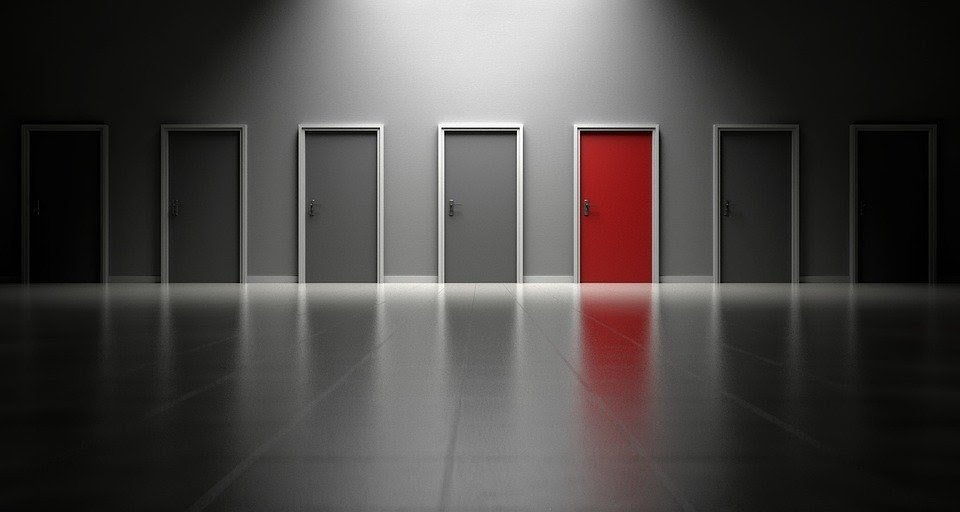 Una puerta roja entre puertas grises.