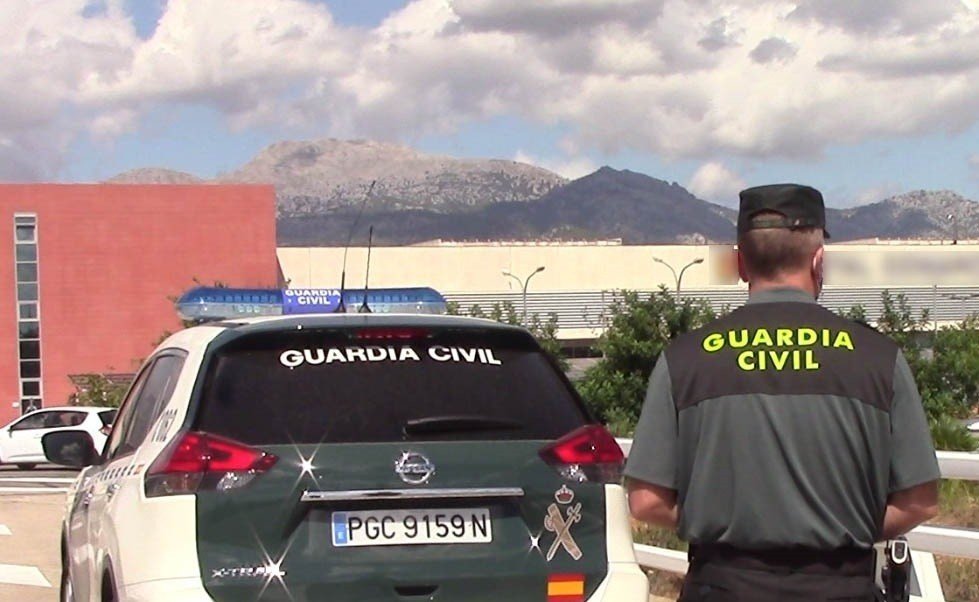 Vehículo de la Guardia Civil y un agente de espaldas.