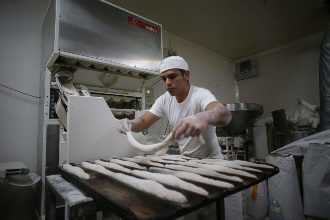 Trabajador elaborando pan en un obrador