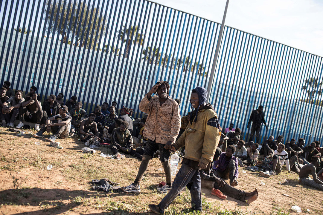 Varios migrantes son atendidos por personal sanitario tras saltar la valla de Melilla en marzo de 2022.