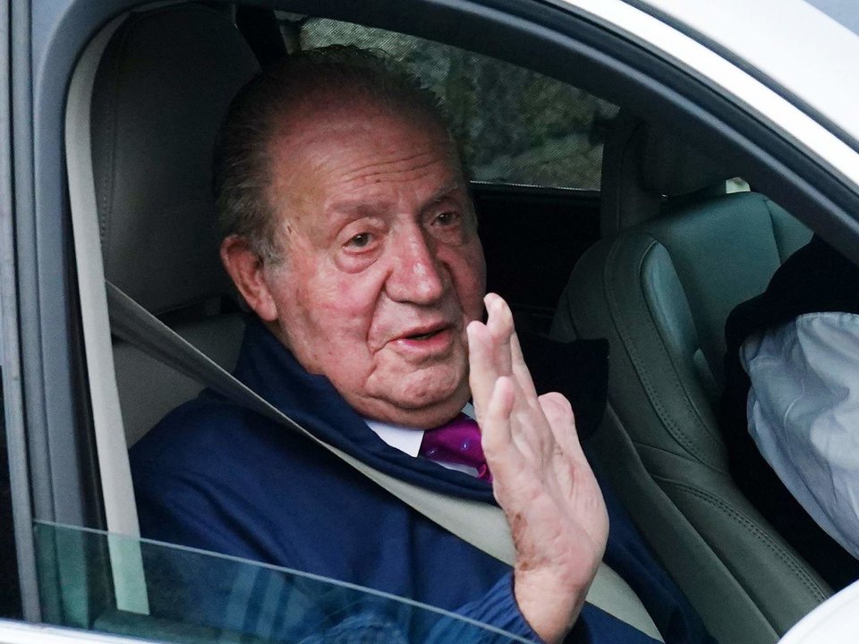 El Rey Emérito Juan Carlos I saluda desde un vehículo a su salida de la casa de Sanxenxo camino de Madrid.