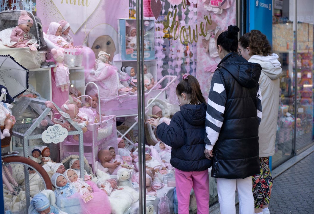 Varias personas miran el escaparate de una tienda de juguetes en Sevilla