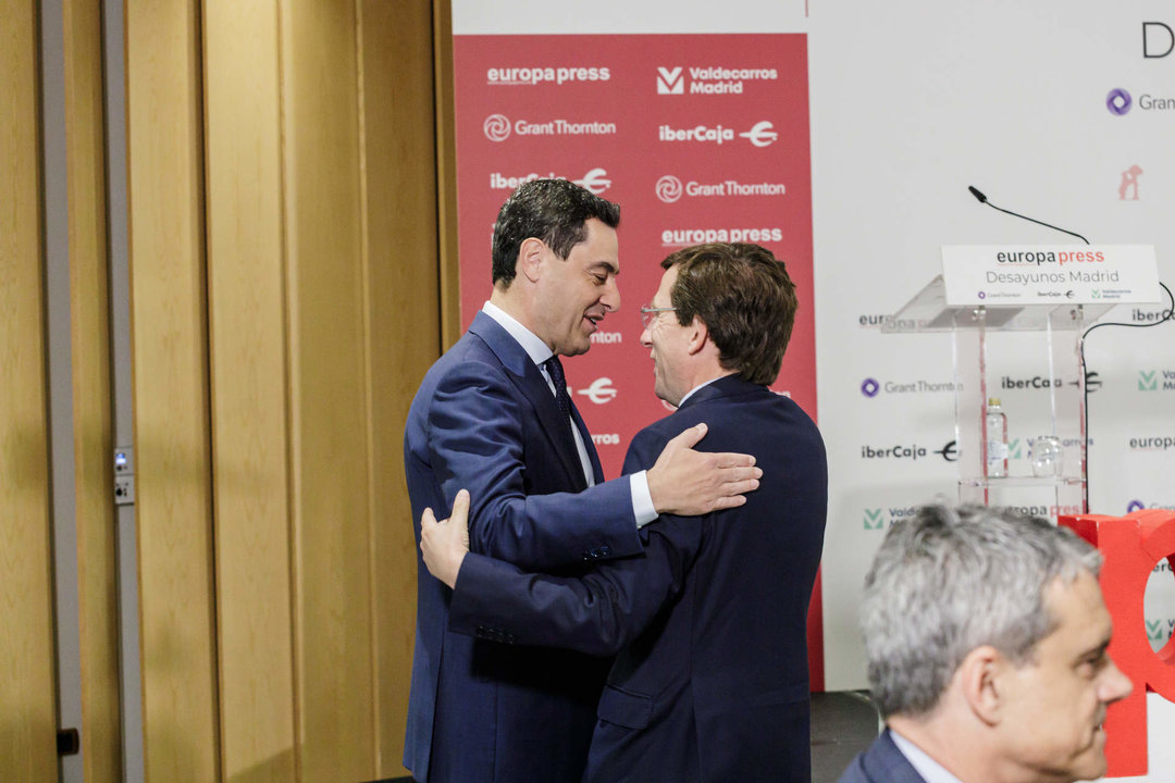 El presidente de la Junta de Andalucía, Juanma Moreno (i) y el alcalde de Madrid, José Luis Martínez-Almeida (d), se saludan a su llegada a un desayuno Madrid de Europa Press, a 10 de mayo de 2023, en Madrid.