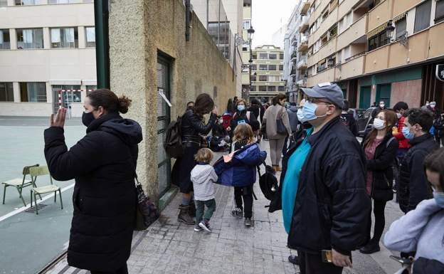 Familias esperando a sus hijos a la salida de clase de un colegio valenciano