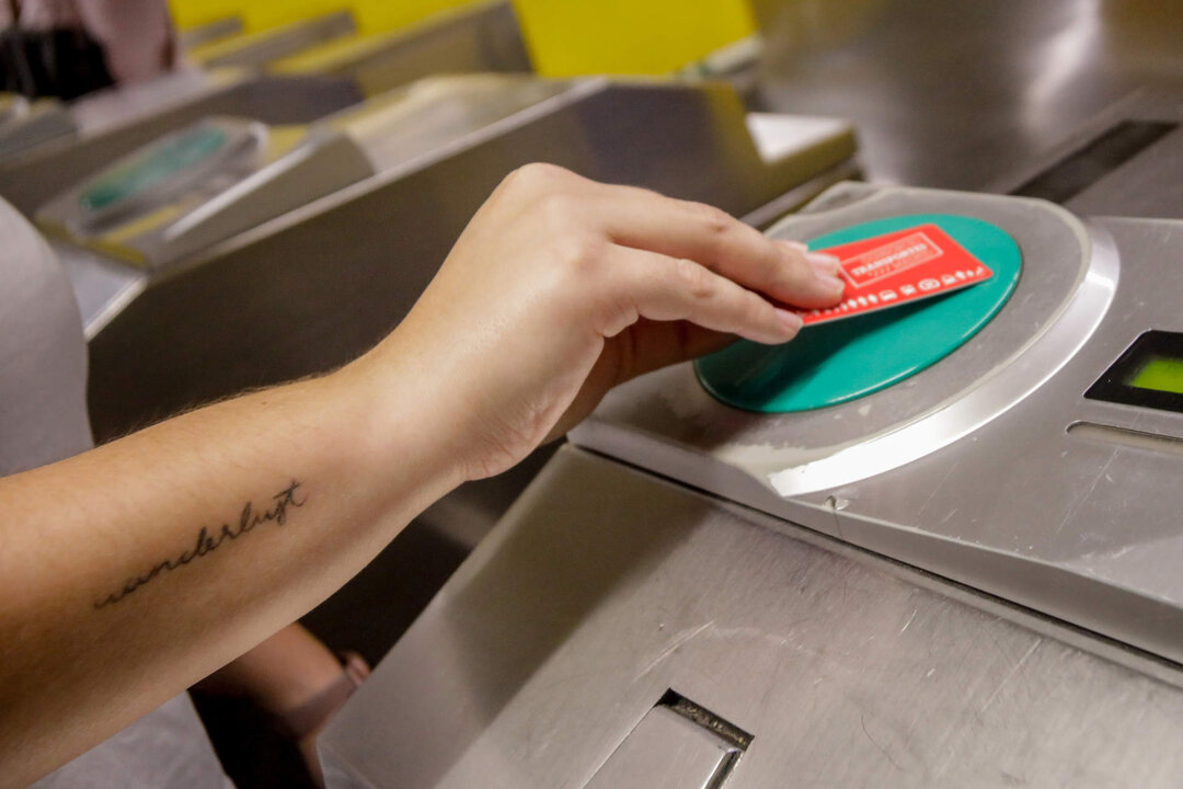Una persona valida su abono en los tornos de entrada del metro de Ciudad Lineal, Madrid (Espa&ntilde;a).