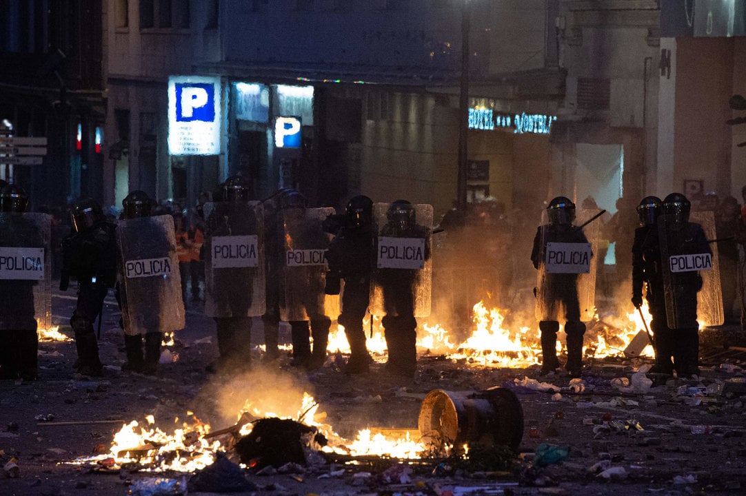Agentes de la Policía Nacional rodeados de hogueras durante los disturbios en la Plaza de Urquinaona, en Barcelona a 18 de octubre de 2019.