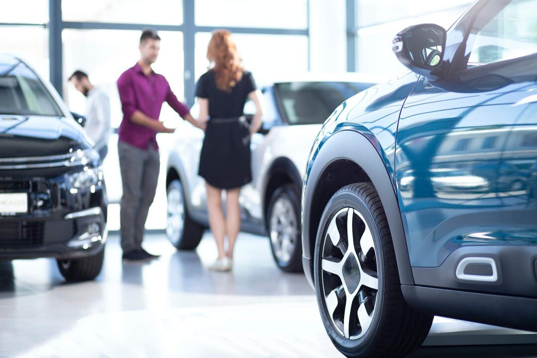 Low angle of exclusive car in a dealing salon with seller and buyer